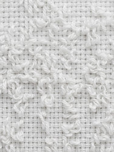 Macro detail shot of premium woven white cotton textile, crisp loops and tight thread structure, bright neutral daylight, B2B commercial photography