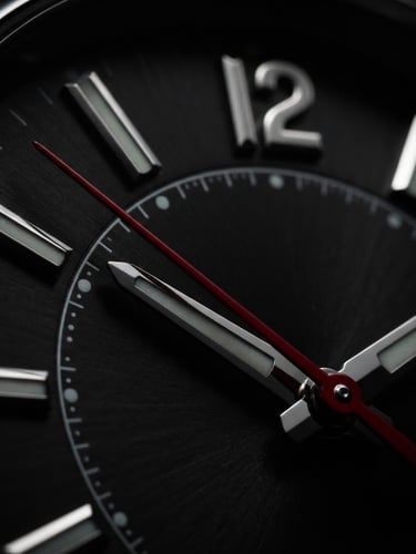 Extreme macro photography of a luxury watch dial, dramatic rim lighting on polished metallic indices, deep black background, sharp crimson second hand.