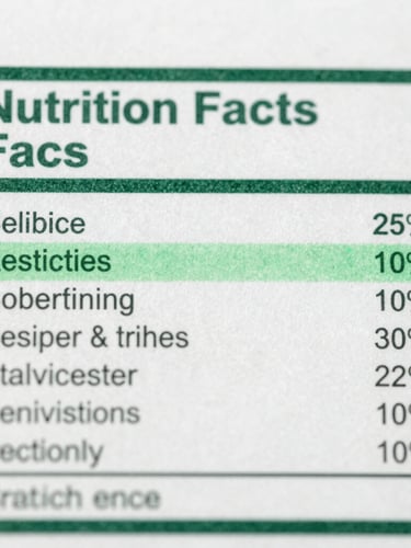 Macro shot of a nutrition facts panel with clinical green highlight overlays indicating technical verification, sharp focus, desaturated tones.