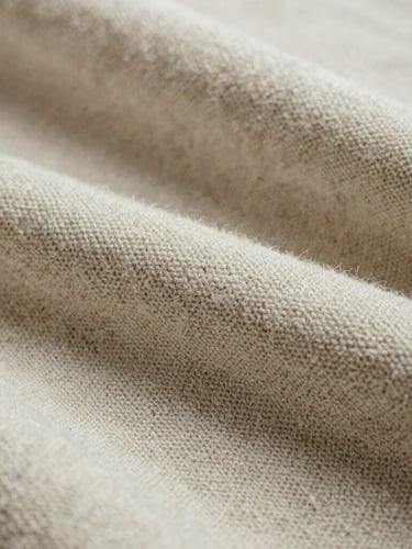 Extreme close-up of raw unbleached cotton textile weave, heavy texture, soft overcast natural daylight, organic beige tones