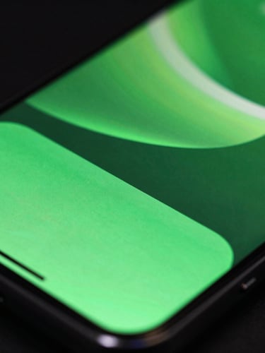 Extreme macro close-up of a high-refresh-rate mobile screen displaying fluid, neon electric green UI transitions, low-key high-contrast studio lighting with dramatic reflections on the glass surface.