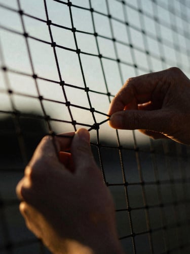 Dynamic ultra-close-up macro shot of hands adjusting the tensioned net, high-contrast dark tones, sharp golden hour sunlight, 35mm film grain.