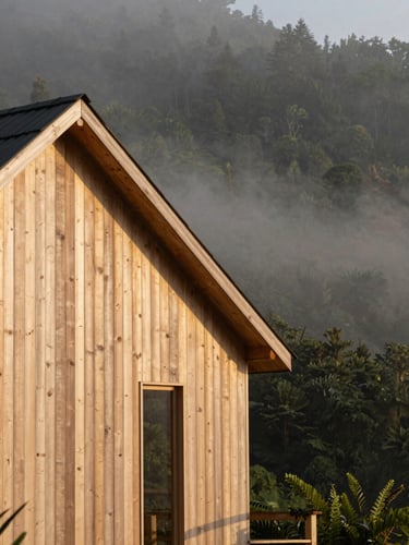 Warm editorial portrait-aspect photography of a modern architectural wooden cabin facade nestled in misty morning Andean forest, soft golden ambient light, 35mm