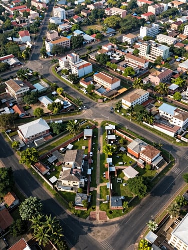 Wide-angle aerial drone photography of a neatly planned residential layout in Hyderabad, showing paved blacktop roads, clear plot boundaries, and green borders under bright mid-morning sunlight.