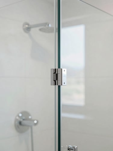 Crisp architectural close-up of a frameless glass shower enclosure, focusing on the heavy-duty chrome hinge and clean, tight joint with zero visible silicone, bright bathroom interior, 35mm lens
