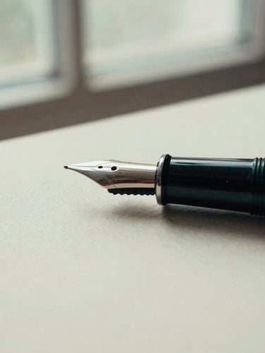 Macro close-up of a heavy fountain pen resting on textured cream paper, soft overcast window light, muted forest green tones, 35mm film style.