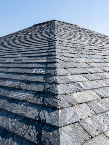 Sharp architectural photography of a newly completed slate tile roof, crisp dry ridge system, bright natural daylight, high-contrast slate and blue tones, wide-angle lens
