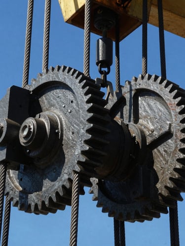 Close-up of industrial steel rigging cables and heavy crane gears under harsh direct sunlight, high contrast, sharp focus on mechanical textures