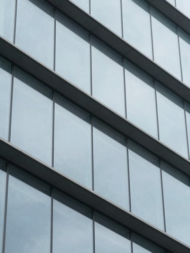 Abstract macro shot of structured modern architectural elements, steel and glass facade, clean grid lines, cool daylight, 35mm.