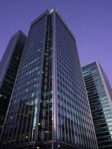 Dynamic low-angle architectural shot of London Canary Wharf skyscrapers reflecting deep violet and cyan twilight sky.