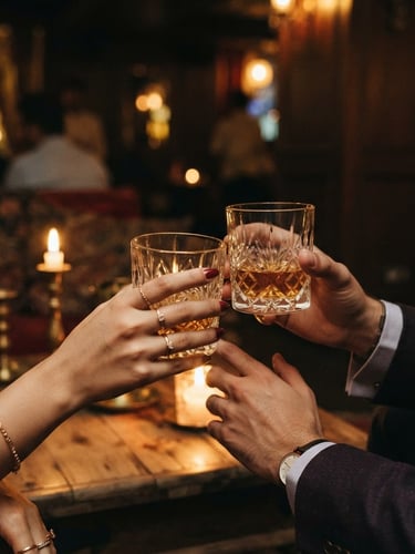 Elegant close-up of hands holding crystal glasses in a candlelit Banjara Hills lounge, warm ambient lighting, shallow depth of field, 35mm