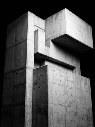 Minimalist black and white photography, high contrast, stark studio lighting, architectural lines of a concrete monolith, sharp focus, 35mm