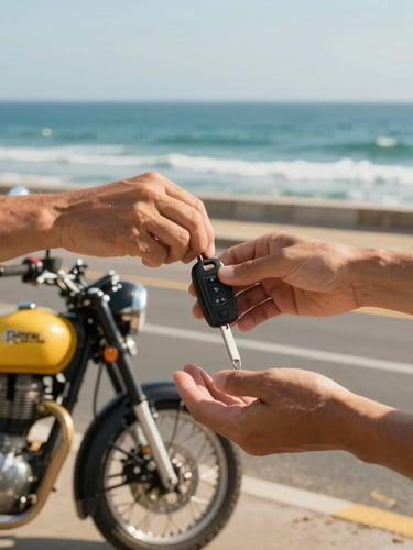 Close-up of hands handing over scooter keys next to a parked Royal Enfield cruiser on CT Road, bright coastal daylight, sharp focus.