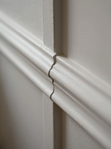 Macro shot of razor-sharp paint lines against skirting boards, natural light, structured framing.