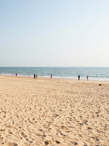 Bright wide-angle shot of Bai Chay Beach at daytime, golden sand, calm sea, people walking, natural sunlight