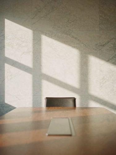 Architectural detail of a quiet, empty classic corporate meeting room, elegant shadows casting across a marble wall, warm natural light, 35mm