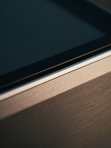 Extreme close-up of high-end hardware, tactile brushed steel and dark glass, soft warm champagne light reflecting off pristine metallic edges, shallow depth of field.