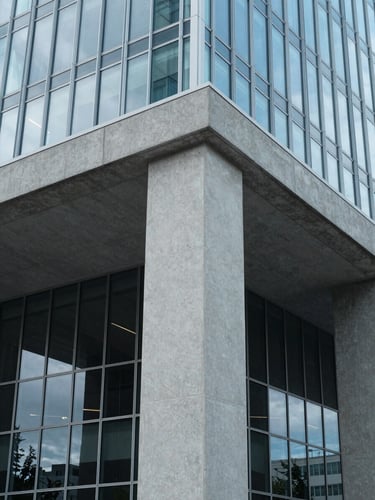 Close-up of a modern architectural concrete column and glass facade of a Canadian corporate headquarters, cool crisp daylight, subtle blue tones, sharp focus, 35mm