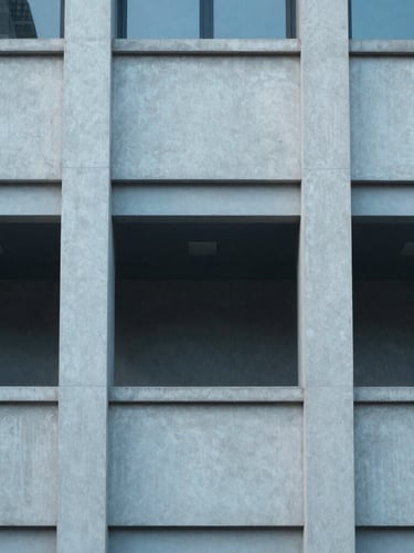 Symmetric architectural detail of a modern civic building, clean concrete lines, cool diffused daylight, 35mm lens
