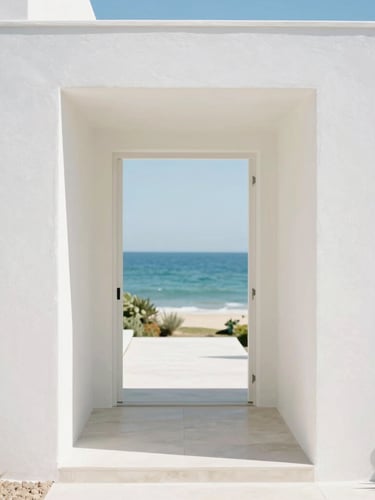 A bright high-key 35mm photo of a pristine luxury coastal estate entryway, warm sun-drenched day, white walls, clean lines, minimalist architecture, shallow depth of field.