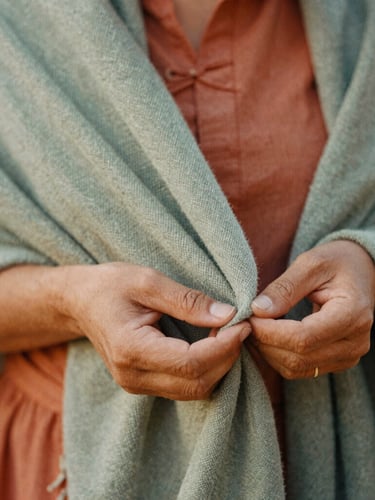 Close-up of traditional practitioner hands gently holding a woven cotton rebozo, warm filtered natural light, earthy terracotta tones, tactile fabric texture, 35mm film