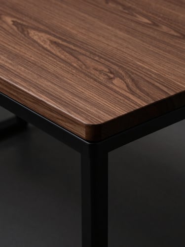 Wide-angle overhead shot of a clean, minimalist walnut desk with zero visible wires, sharp 90-degree cable bends routed along matte black steel legs, moody side-lighting.