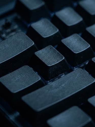 Macro shot of mechanical keyboard keys in low-key cool-toned studio lighting, deep midnight blue shadows, sharp focus on keycaps
