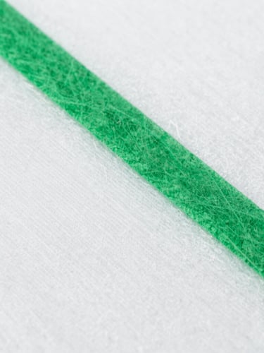 Macro shot of raw spunlace nonwoven fabric texture, bright sterile white laboratory light, clean green details, sharp focus