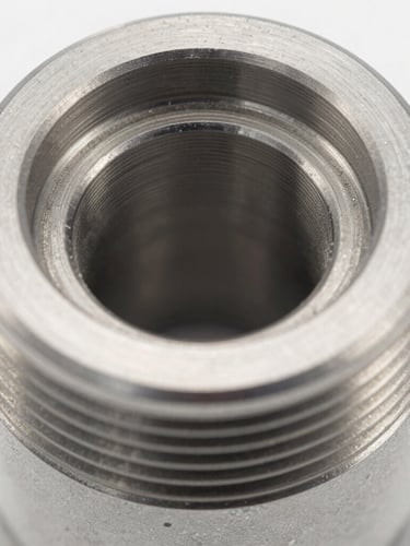 Extreme close-up macro shot of a small, highly precise machined steel automotive component with clean threads, bright cool studio lighting, metallic reflections