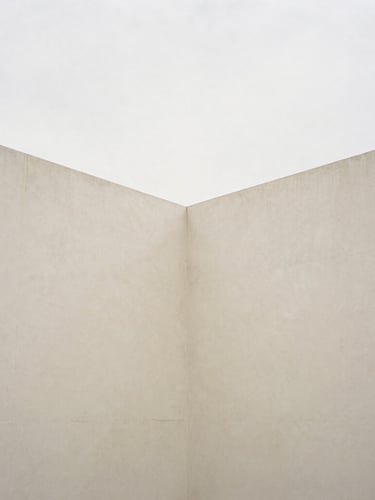 Minimalist architectural composition of intersecting concrete planes, soft overcast daylight, subtle shadows, cream and muted earth tones, 35mm