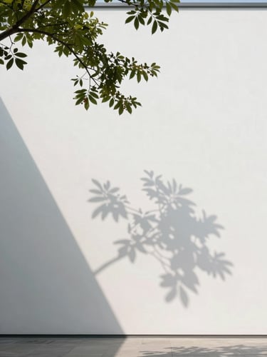 Architectural shadow of a branch falling across a blank white gallery wall, soft diffused indirect daylight, portrait orientation, minimalist composition.