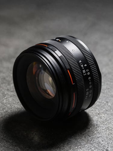 High-contrast product close-up of a premium lifestyle item, direct harsh flash, deep shadows, raw concrete background.