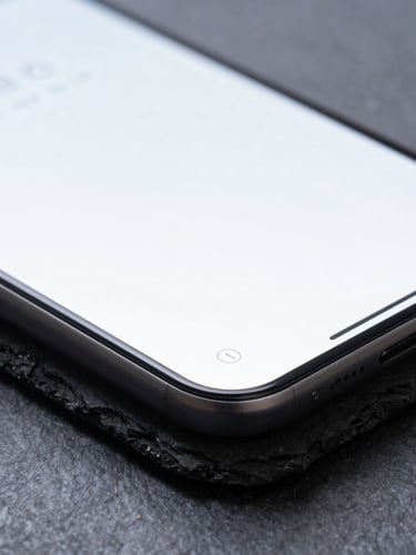 Macro photograph of a sharp slate stone edge contrasting with a clean, glowing mobile UI wireframe on a screen, cool studio lighting, sharp shadows.