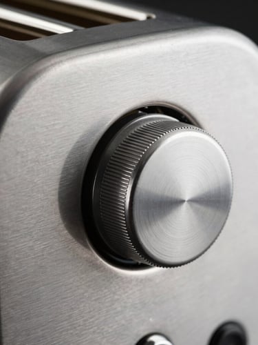 Extreme close-up of a brushed steel toaster dial, high-contrast side-lighting, heavy mechanical detent, sharp industrial product photography, 50mm