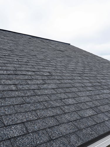 Sharp wide-angle construction photography of a newly installed asphalt shingle roof on a Syracuse home, bright overcast daylight, realistic saturated colors
