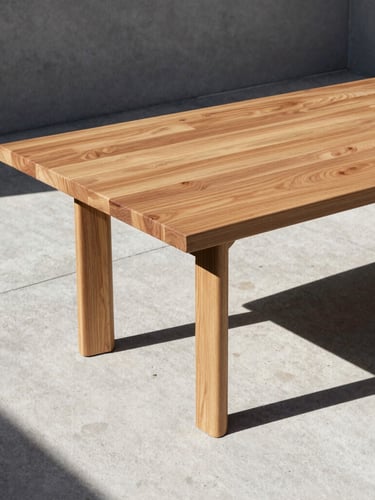 Architectural dining table on a raw concrete terrace, sharp structural shadows from harsh direct sunlight, warm cedar wood grain, minimalist composition, 35mm