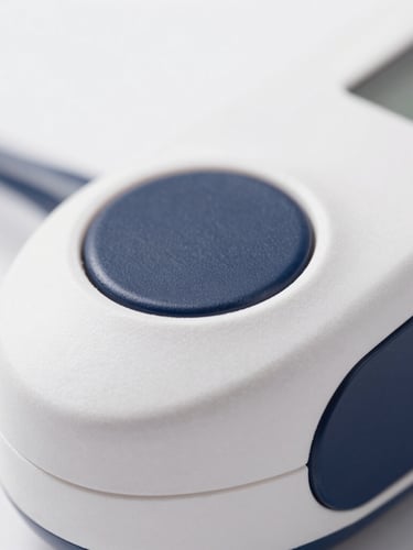 Macro shot of a premium medical device with diffused studio lighting, shallow depth of field, white and deep navy tones
