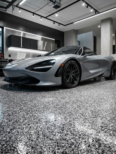 Low-angle architectural shot of a high-end sports car parked on a flawless glossy gray flake polyurea floor, dramatic direct lighting highlighting the textured vinyl flakes, pristine garage interior, crisp details