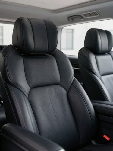 Macro editorial shot of premium black leather seats in a Mercedes V-Class, soft lighting highlighting the texture, executive rear cabin, quiet luxury, 35mm