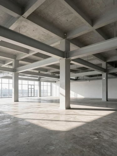 Wide-angle view of a modern commercial interior with exposed structural steel beams and concrete flooring, bathed in high-contrast morning light, clean geometric lines