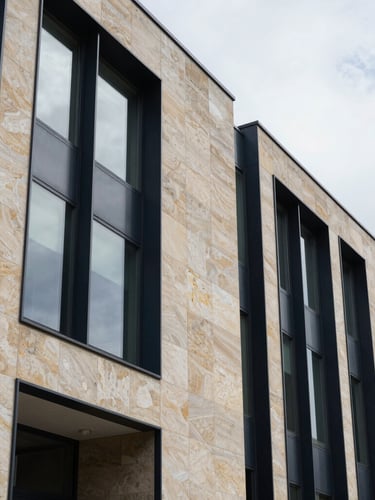 Architectural detail of a modern limestone and steel office facade, crisp shadows, natural overcast daylight, editorial corporate style, 35mm
