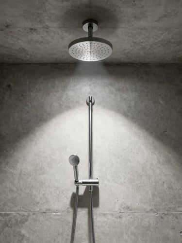 Symmetrical, dead-center architectural crop of a minimalist concrete bathroom, a single spotlighted chrome rain shower head projecting from the ceiling, casting a sharp shadow.