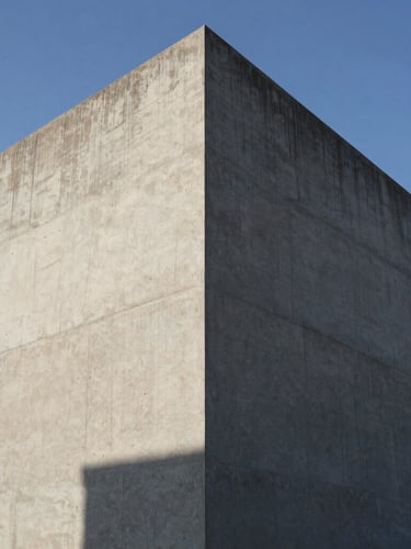 Extreme wide-angle environmental shot of a raw concrete facade under hard direct sunlight, graphic shadows cutting across the geometric volume, clear sky.