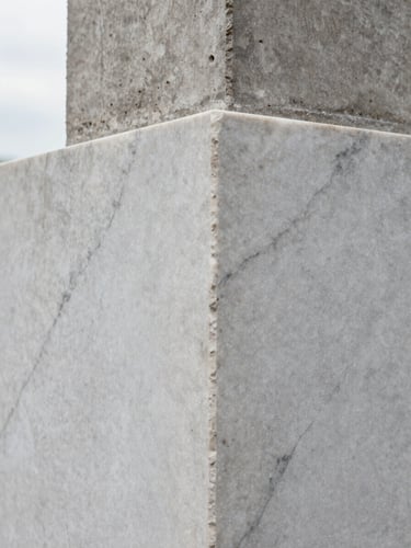 Tight geometric detail crop of marble grain and raw concrete intersection, soft diffused overcast daylight highlighting the material texture.