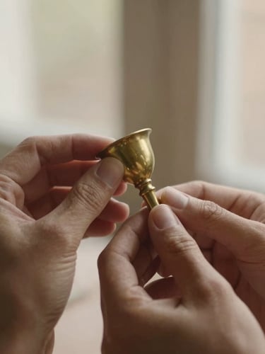 Close-up, shallow depth of field shot of artisan hands gently polishing a brass ritual object, warm soft side-lit window daylight, muted earth tones with subtle gold accents, 35mm.