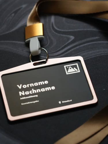 Professional identification badge in a holder with a gold lanyard on a dark marble surface.