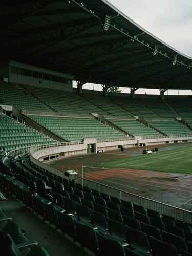An empty architectural stadium tunnel, dramatic low-key lighting, cinematic shadows, deep green cast, moody overcast European daylight.