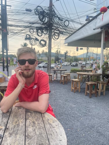 mężczyzna w okularach siedzi przy stole Tajlandia