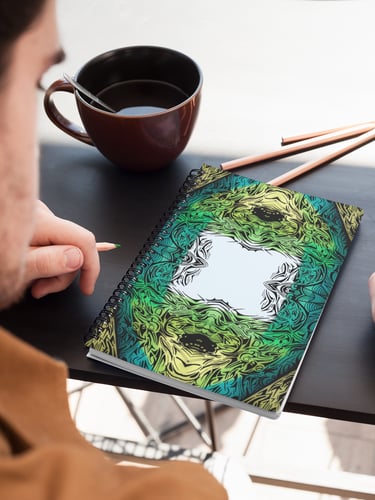 a man is sitting at a table with a notebook and a cup of coffee