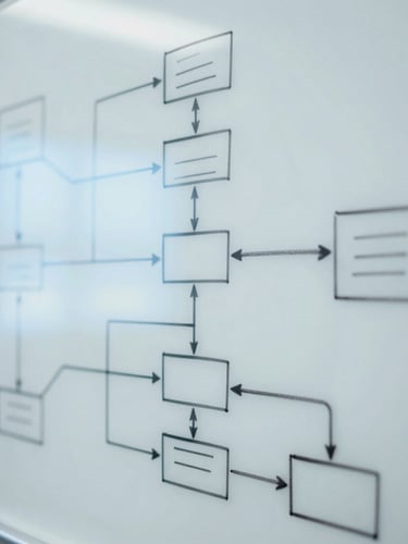 Close-up of complex system architecture diagrams drawn on a clean white whiteboard, soft blue ambient lighting, crisp editorial photography